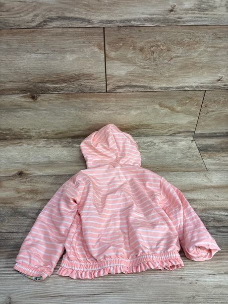 Back view of reversible waterproof jacket showcasing pink and white stripes, hood, and ruffled hem on wood flooring