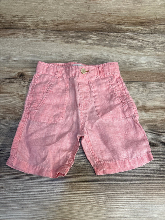Pink toddler shorts with front pockets on wood background, gently used kids clothing.