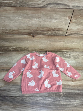 Pink baby sweater with white bunny print, long sleeves, laid on wood floor