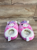Pink unicorn plush slippers for kids with purple mane and horn on wooden floor