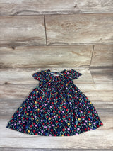 Flat-lay of girl's navy tulip-print dress, size 18 months, short sleeves and gathered waist on wood floor
