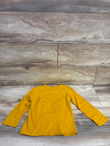 Back view of Children’s Place Thankful Little Dude shirt in yellow, size 5T, showing long sleeves on a wood-grain background