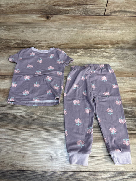 Purple floral toddler pajama set with pink flowers, short sleeve top and pants on wood floor
