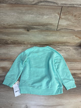 Mint green kids sweatshirt, size 5T, laid flat on wood floor with tag visible — great for children's clothing resale.