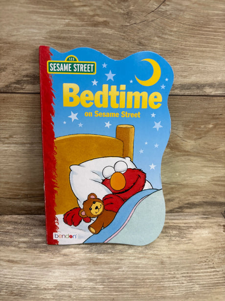 Front view of Bedtime on Sesame Street hardcover book showing Elmo sleeping with a teddy bear under a moon and stars