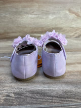 Back view of NWT Gymboree floral ballet flats in shimmery lavender showcasing pink flower strap and hangtag with wood plank floor