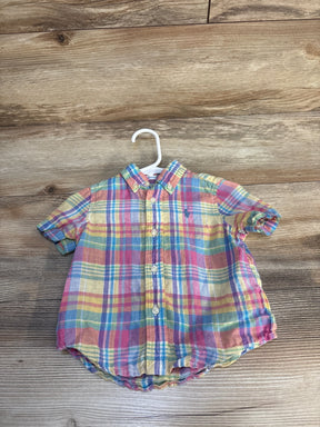 Colorful plaid short sleeve button-up toddler shirt on hanger, wood background