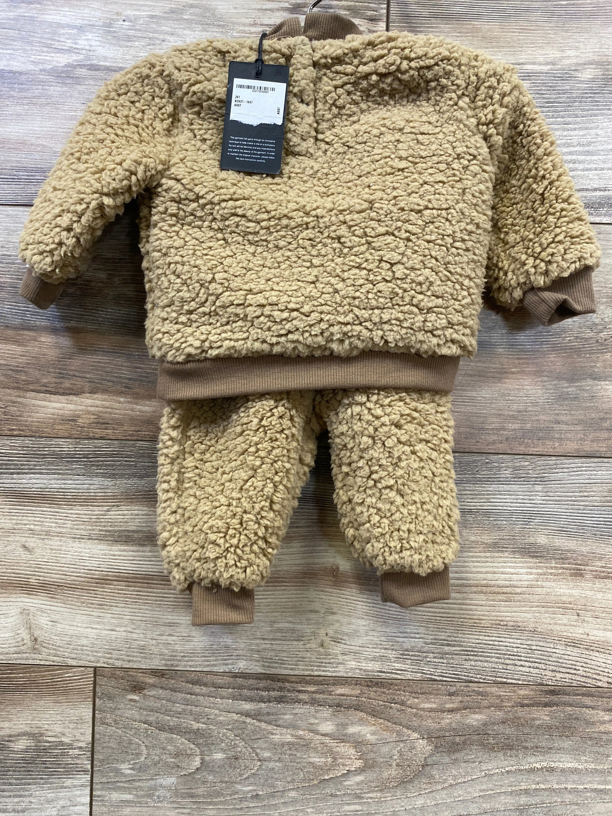 Tan sherpa fleece toddler outfit with sweater and pants on wood background