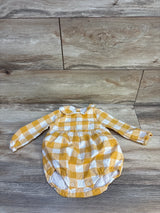 Yellow and white gingham baby romper with long sleeves, laid flat on wood floor