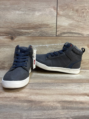 Pair of navy blue kids high top sneakers with white soles on wood floor