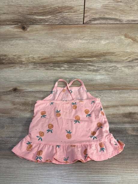Flat lay of pink OshKosh 24-month tank top with pineapple print, ruffle hem, and crossed straps on light wood background