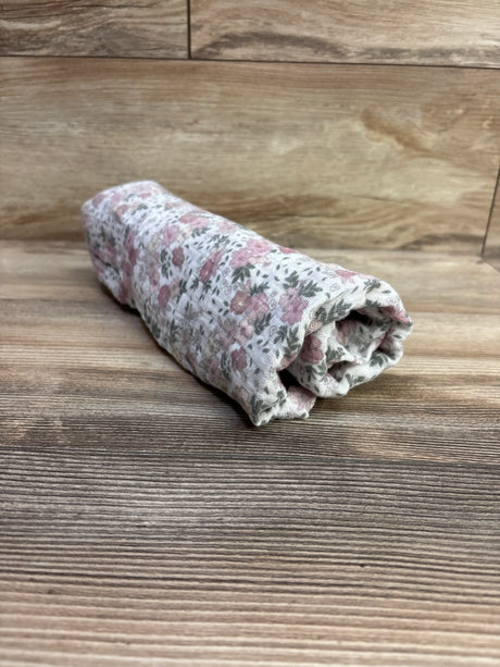 Rolled view of Modern Baby Floral Muslin Swaddle Blanket White showcasing pink floral pattern on white muslin with wood background