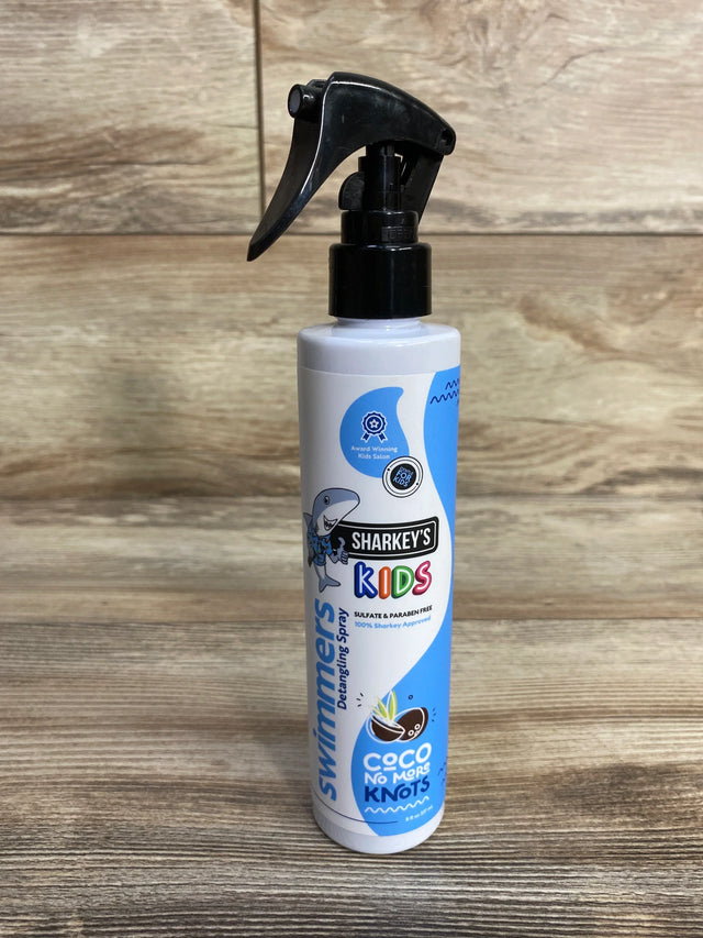 Front view of Sharkey's No More Knots 8 oz detangler spray bottle showing trigger sprayer and blue kids label on wood background