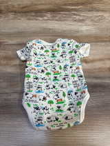 Baby bodysuit with sheep, shamrock, and Ireland-themed prints on wooden background
