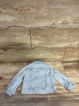 Back view of Cat & Jack light blue denim jacket, 12-month size, showing button cuffs and back yoke stitching on wood background