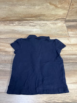 Back view of a navy blue Children's Place polo shirt for toddlers size 3T on a wood surface