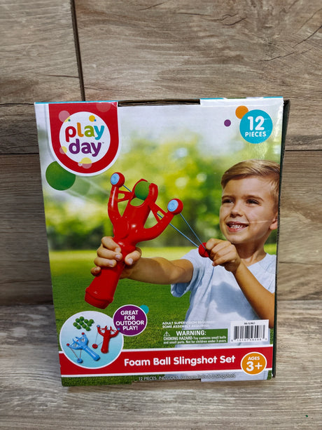 Child playing with Play Day foam ball slingshot set for ages 3 and up, 12 piece outdoor toy.