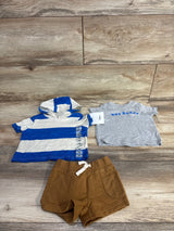 Flat lay of 3-piece baby set size 3M showing blue-and-white hooded shirt, grey hey buddy tee and brown shorts on wood background