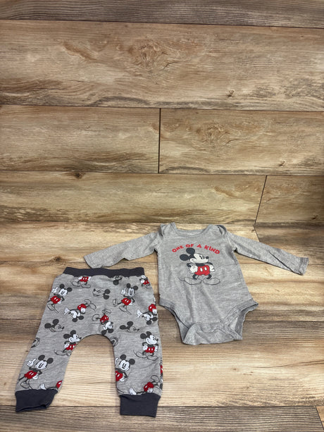 Top view of grey Disney Baby Mickey Mouse bodysuit and pants set showing long sleeves and character prints on a wood background