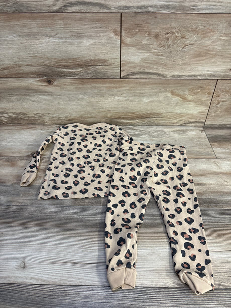 Top-down view of girls H&M 2-piece leopard print pajama set size 2T showing long-sleeve top and cuffed pants on wood background