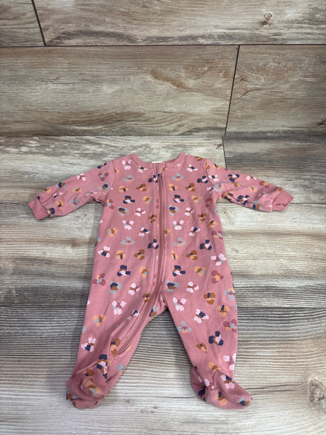 Front view of pink baby sleeper showcasing an all-over multicolor pattern, front zipper, and covered feet on a wood-look background