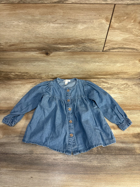 Baby denim long sleeve top with front buttons, laid on wood floor