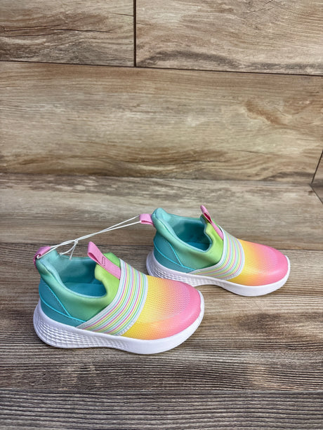 Angled top view of Cat and Jack toddler slip-on sneakers showing rainbow gradient upper, elastic striped band, and white cushioned sole on wood background