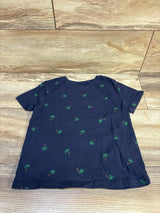 Flat lay of navy Old Navy toddler short-sleeve T-shirt showing small green palm tree all-over print on wood floor background
