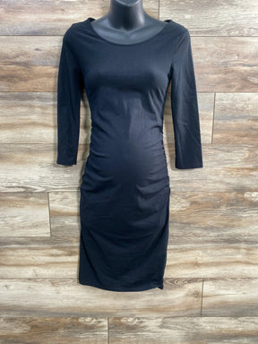 Front view of Isabel maternity black bodycon dress with ruched sides and three-quarter sleeves against wood background