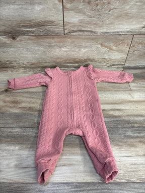 Pink cable knit long sleeve baby romper with ruffle shoulders on wood background