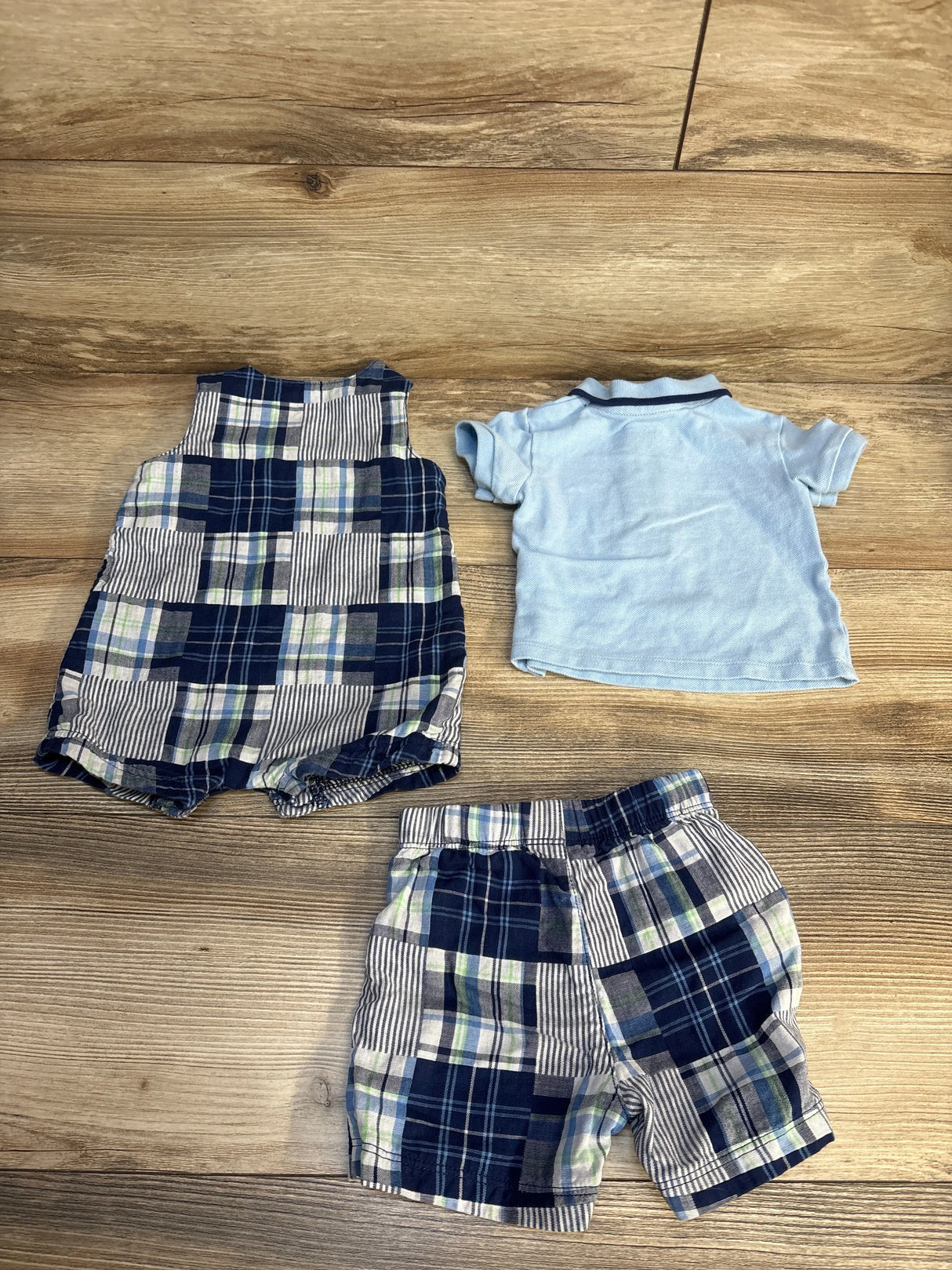 Baby boy plaid romper, matching shorts, and blue polo shirt on wooden floor