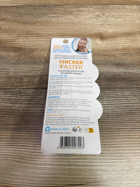 Back view of Bumco Baby Bum Brush packaging showing diaper cream application instructions on a wood surface