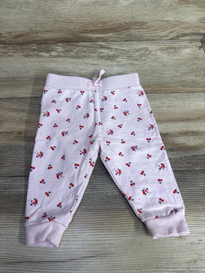 Light pink toddler pants with red cherry and flower print, ribbed cuffs and waistband on wooden floor