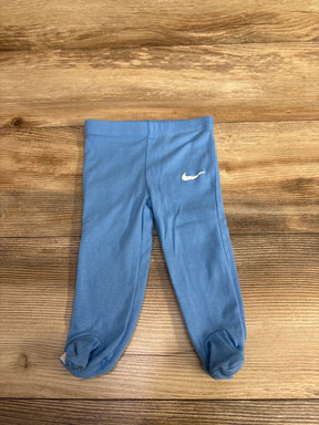 Blue baby leggings with white Nike logo on wooden surface, children's activewear