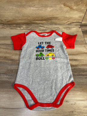 Front flat-lay of M&M 'Let the Good Times Roll' baby bodysuit showcasing colorful car graphic and text on wood background