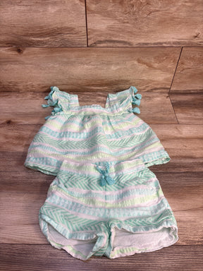 Flat lay of toddler white and mint striped two-piece set showing tassel sleeves and braided drawstring on wood background