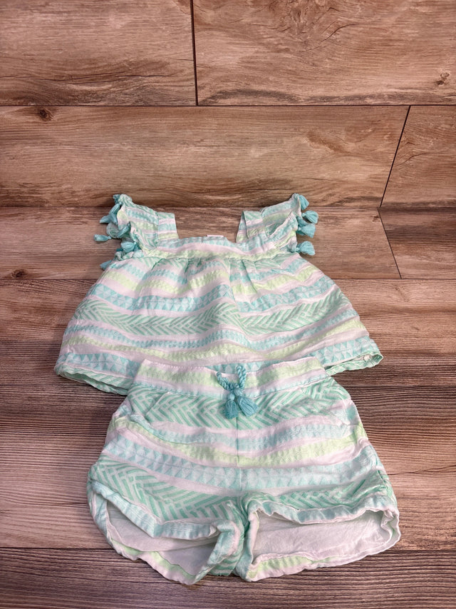 Flat lay of toddler white and mint striped two-piece set showing tassel sleeves and braided drawstring on wood background