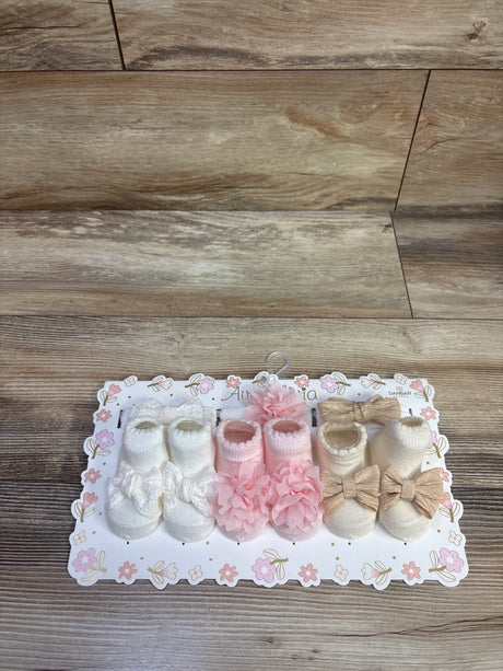 Top view of Ava and Olivia 6-piece headwrap and bootie set showcasing white, pink, and beige booties with bows on floral packaging