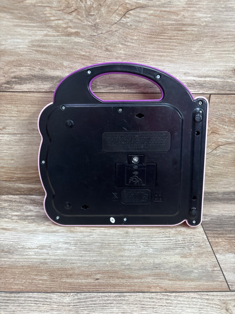 Back view of LeapFrog Scout and Violet 100 Words Book in pink with carry handle on a wood surface