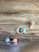 Wooden baby rattles and toys in pastel colors on a wooden surface