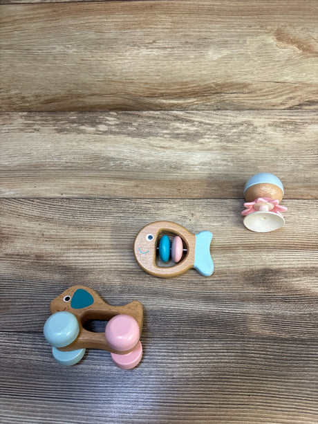 Wooden baby rattles and toys in pastel colors on a wooden surface