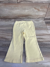 Flat lay of yellow Baby Gap ribbed flare leggings, size 18-24 months, showing elastic waist and flared legs on wood floor
