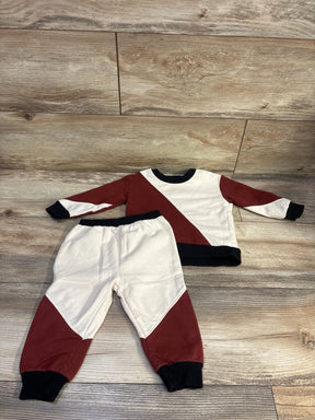 Front view of Mini Threads red and cream sweatshirt and joggers set for 12 months showing color-block design on wood floor
