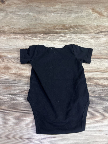 Back view of a black baby bodysuit showcasing short sleeves and a plain back with a wood-look background