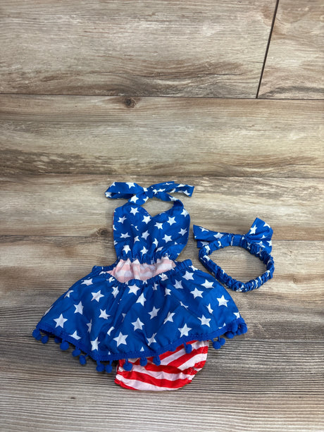 Top down view of halter bubble romper and headband showing blue stars, striped bloomers, and pom pom trim on wood background
