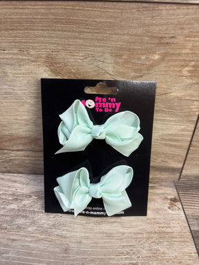 Front view of two mint green grosgrain hair bows on black Me 'n Mommy To Be display card with wood background