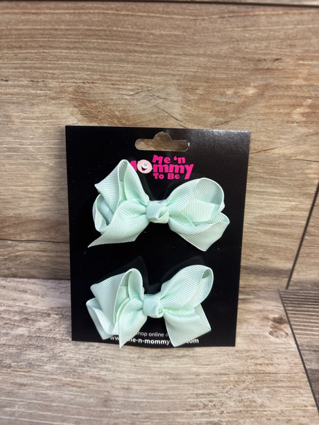 Front view of two mint green grosgrain hair bows on black Me 'n Mommy To Be display card with wood background
