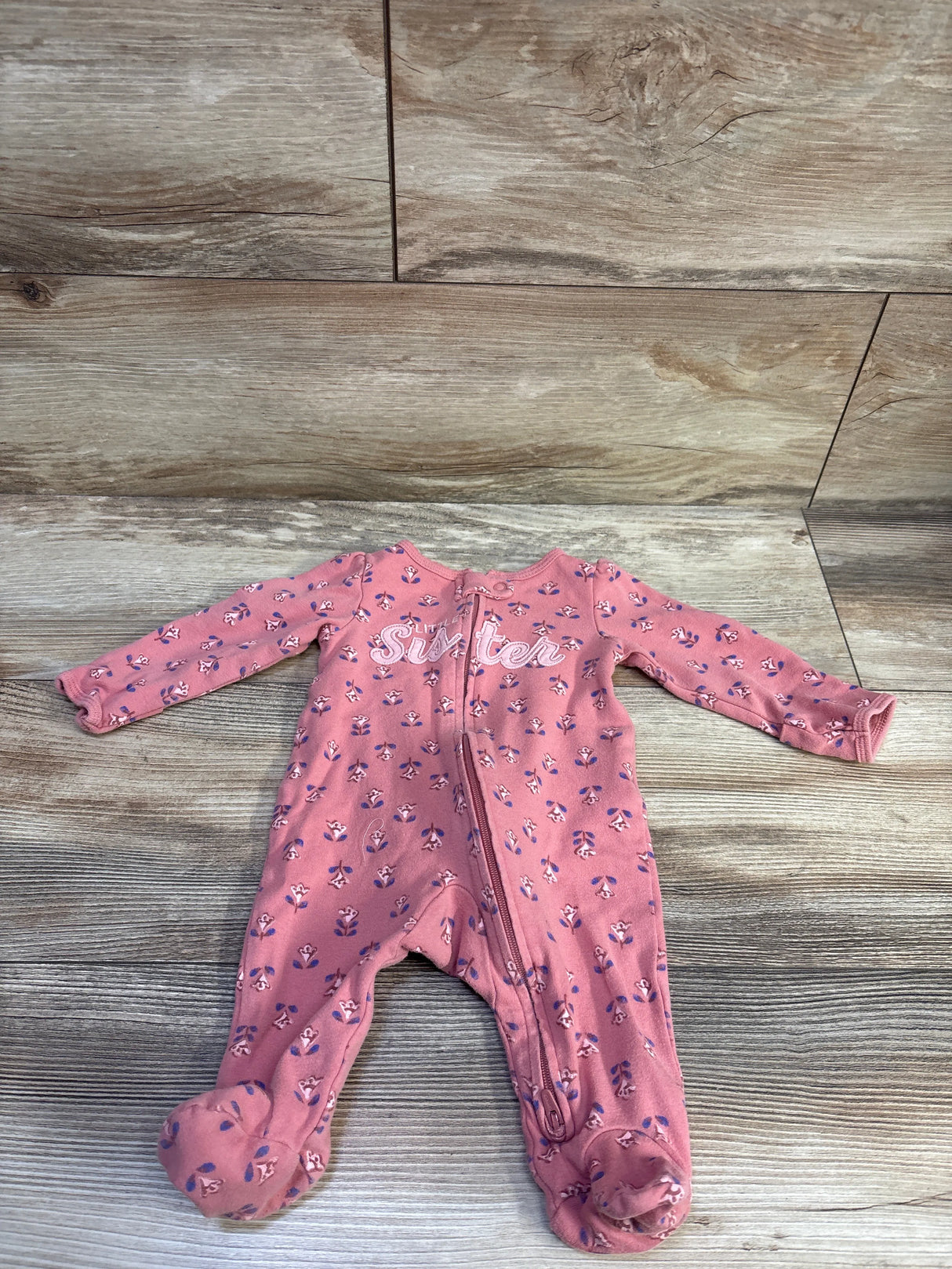 Front view of Carter’s Little Sister pink footed sleeper in size 3 months with floral print and zipper on wood floor