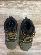 Pair of olive green toddler hiking boots with black padded collars and yellow-black laces on wood floor