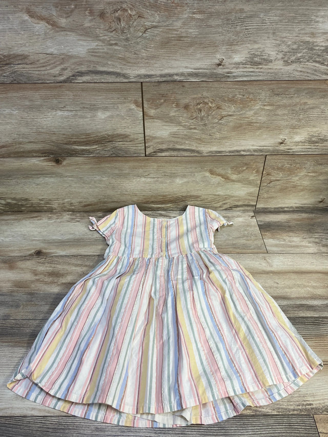 Flat lay of OshKosh girls' pastel striped button-front dress, short tied sleeves and gathered skirt on wood background